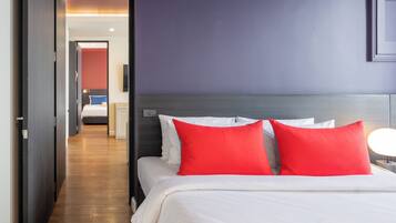 A hotel room with a bed, a nightstand, and a wall-mounted TV.