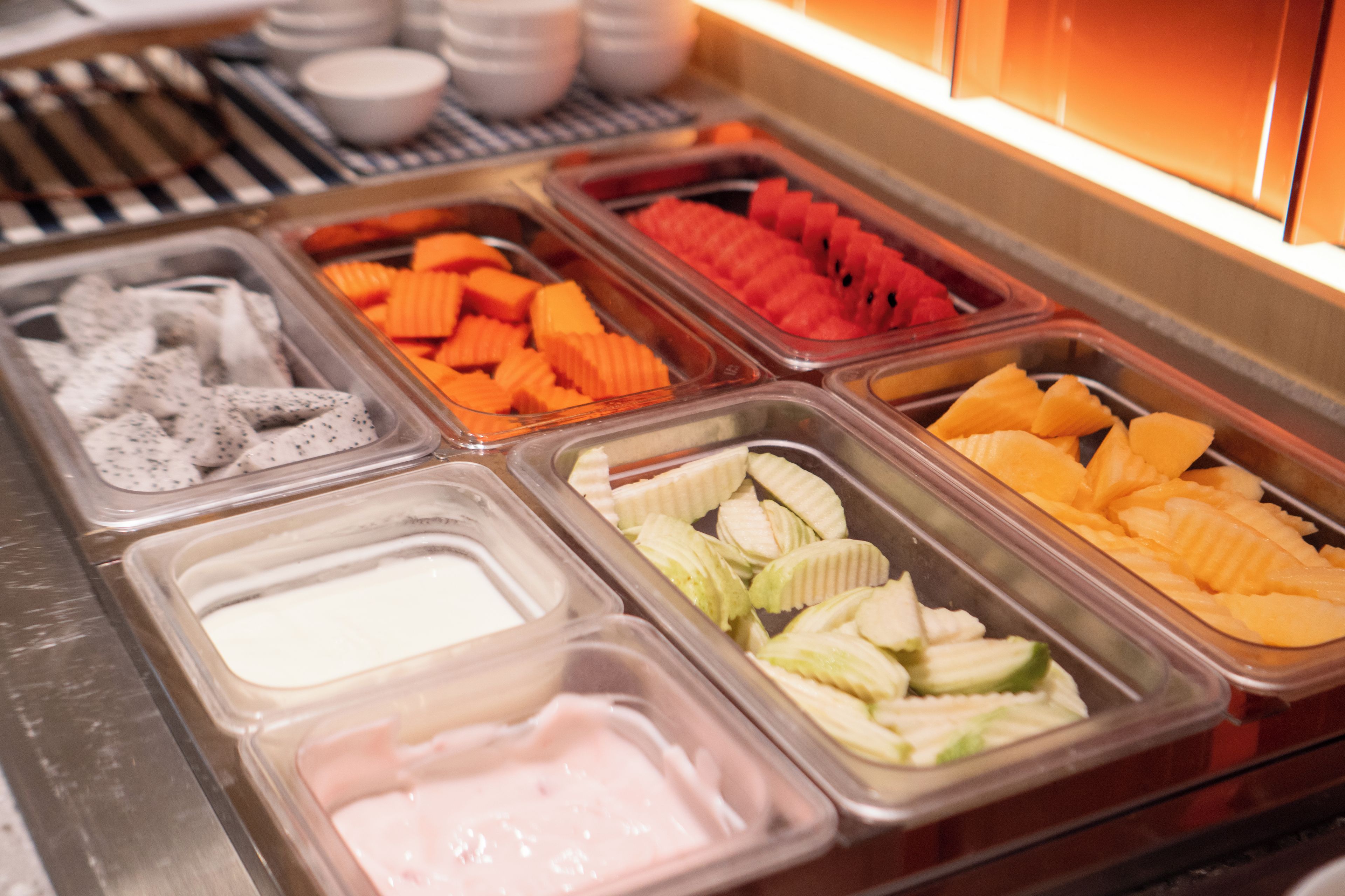 Un bufé con varios alimentos en recipientes separados.