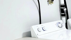 A white washing machine with control knobs and a power cord. - Cottage close to Seaside Heights beach, Parking (Seaside Heights)