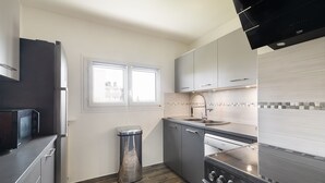 A modern kitchen with a stainless steel stove, a microwave, and a trash can. - Magnificent apartment between Paris and Disneyland. Rer A 10 min by bus -PARKING  (Neuilly-sur-Marne)