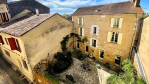 Un cortile con pavimento in pietra, un piccolo tavolo e sedie.