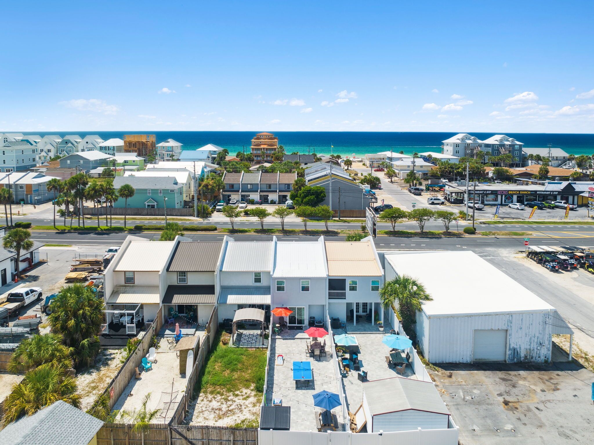 Un hôtel situé sur la côte, doté d’une grande terrasse, offrant une vue sur la plage et disposant d’un parking.