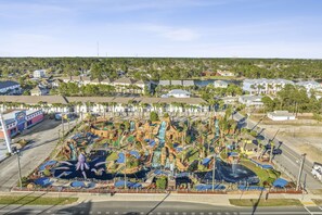 Een groot waterpark met diverse waterattracties, waaronder watervallen en zwembaden, omringd door woongebouwen.
