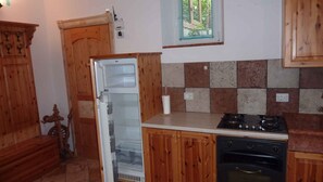 A kitchen with wooden cabinets, a refrigerator, a stove, and an oven. - Holiday apartment with terrace and parking (Tenno)