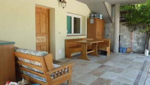 A room with a wooden bench, a table, a window, and a door.