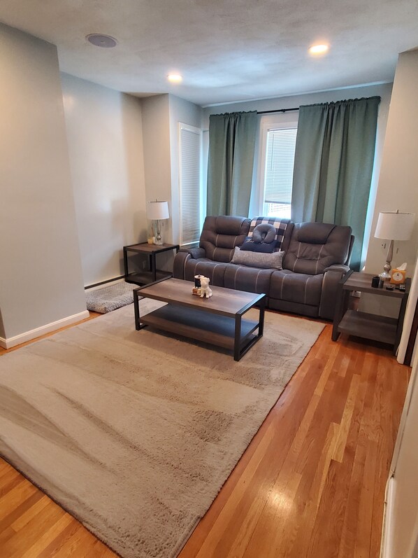 A living room with a sofa, coffee table, and lamps.