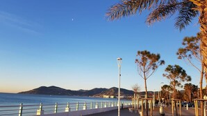 A coastal promenade with a white railing, street lamps, and trees. - Rue d'Antibes Premium 2 BDR 2 baths Exclusive Olam Properties Cannes (Cannes)