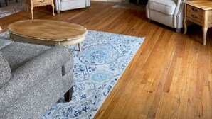 A living room with two armchairs, a sofa, a coffee table, and a fireplace. There is a wooden cabinet and a mirror on the wall. - Four Bedroom Bellevue Beauty (Bellevue)