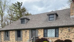 A two-story stone house with a sloped roof, a front porch, and a well-maintained lawn. - Four Bedroom Bellevue Beauty (Bellevue)