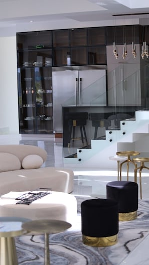 Relax in a stylish space with a comfortable sofa, dining area, and kitchenette, perfect for unwinding.