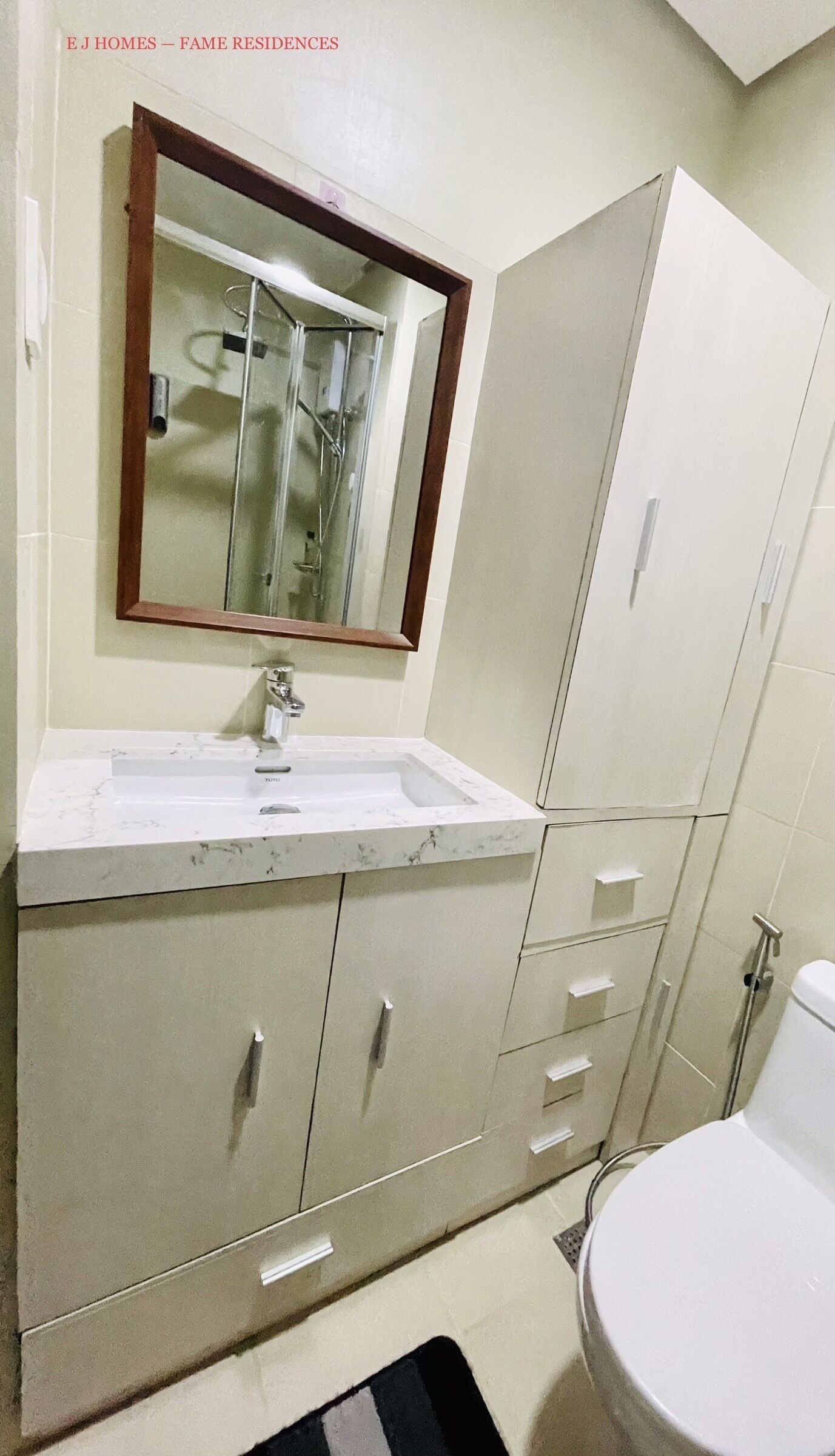 Une salle de bain avec un lavabo blanc, un miroir et des armoires.