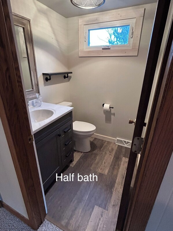 Une petite salle de bain avec des toilettes, un lavabo et un miroir.