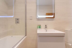 Chuveiro, secador de cabelo, toalhas de banho, papel higiênico