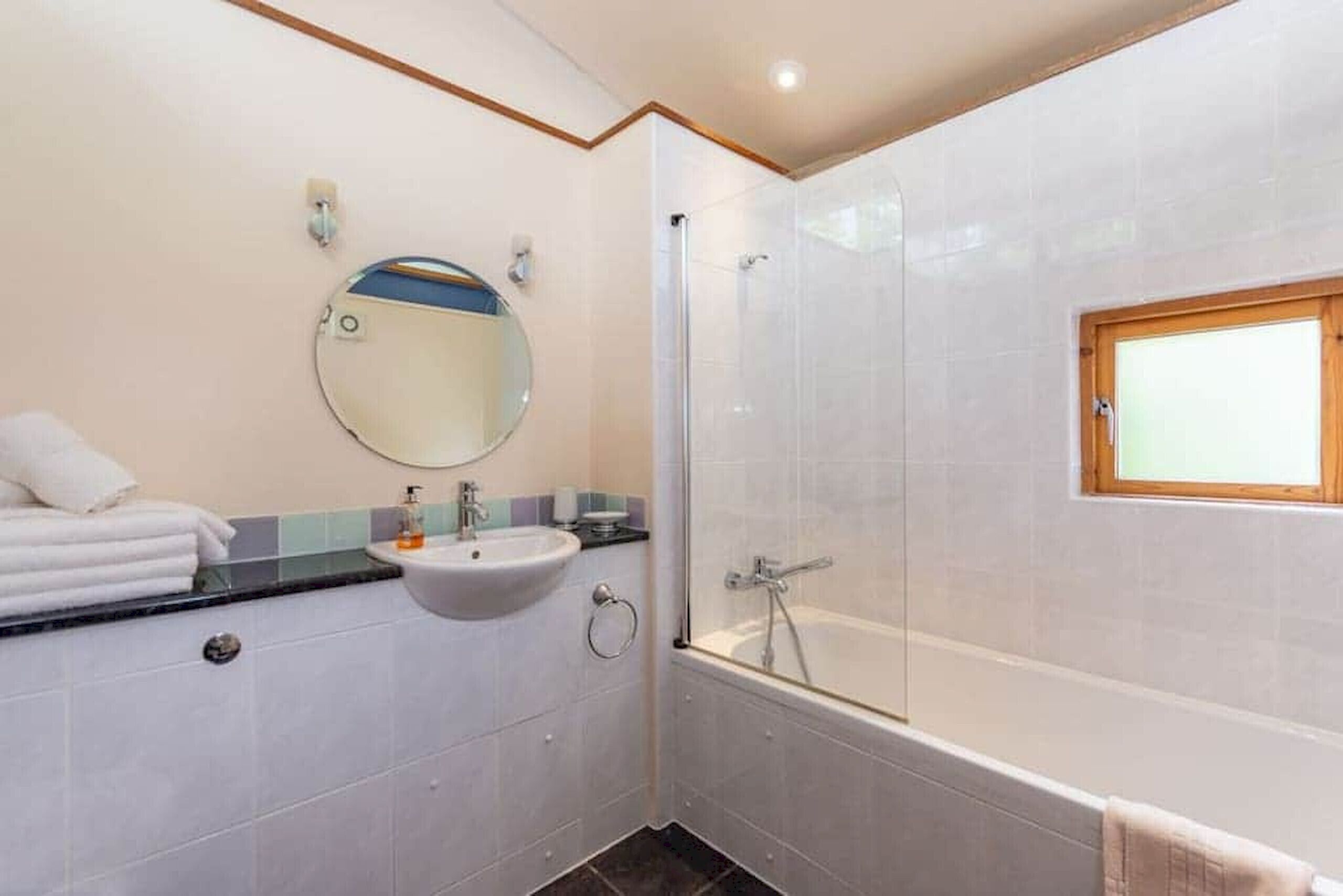 Une salle de bain avec un lavabo, un miroir et une douche.