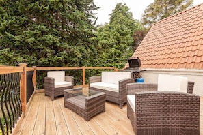 An outdoor deck with wicker furniture and a grill. - Muir Park Cottage (Grange)