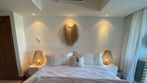 A neatly made bed with a patterned bedspread, two bedside lamps, and a wall-mounted light fixture.
