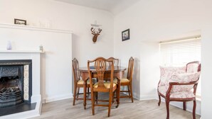 Comedor con chimenea, sillas de madera y una mesa.