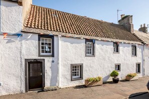 A traditional white building with a tiled roof, multiple windows, and a door. - The Cooperage | Crail (Crail)
