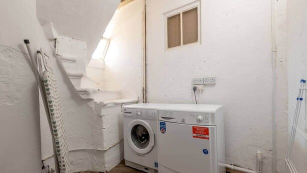 A laundry room with a washing machine, a drying rack, and a small window. - The Doctor's House (St Andrews)