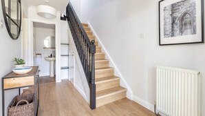 A staircase with a black balustrade leading to a landing. - Abbey Villa (No 6) (St Andrews)