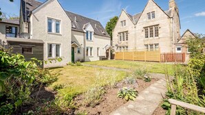A traditional stone house with a well-maintained garden and a wooden fence. - Abbey Villa (No 6) (St Andrews)
