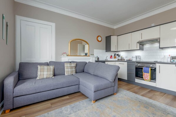 A modern kitchen with white cabinets, a built-in oven, and a microwave.