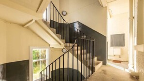 A staircase with black railings leading to a landing. - Argyle Street Apartment (No 44) (St Andrews)