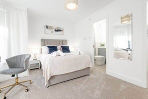 Una habitaci ón de hotel moderna con una cama, una silla, una mesita de noche y un espejo grande.