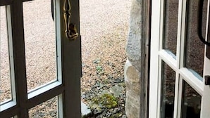 A stone building with a gravel driveway leading to a greenhouse. - Park Mill Cottages | The Granary (St Andrews)