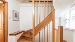 A wooden staircase with a handrail, carpeted floor, and a framed picture on the wall. - Crail Town House (Crail)