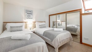 A hotel room with two beds, a large mirror, and a wall with a motivational quote. - Crail Town House (Crail)