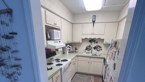 A compact kitchen with a microwave, stove, and refrigerator.