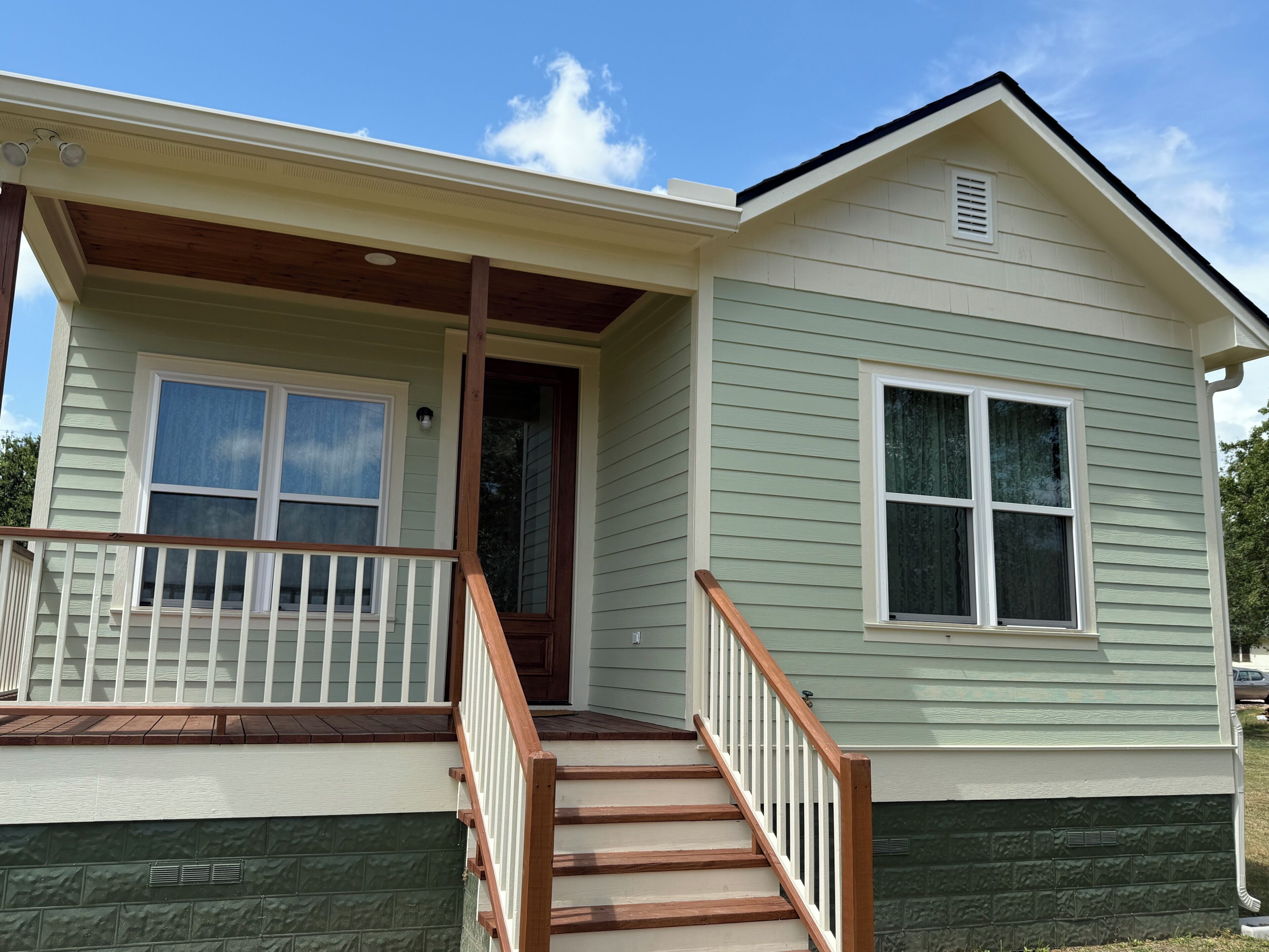 A two-story house with a front porch, a staircase, and a garage.