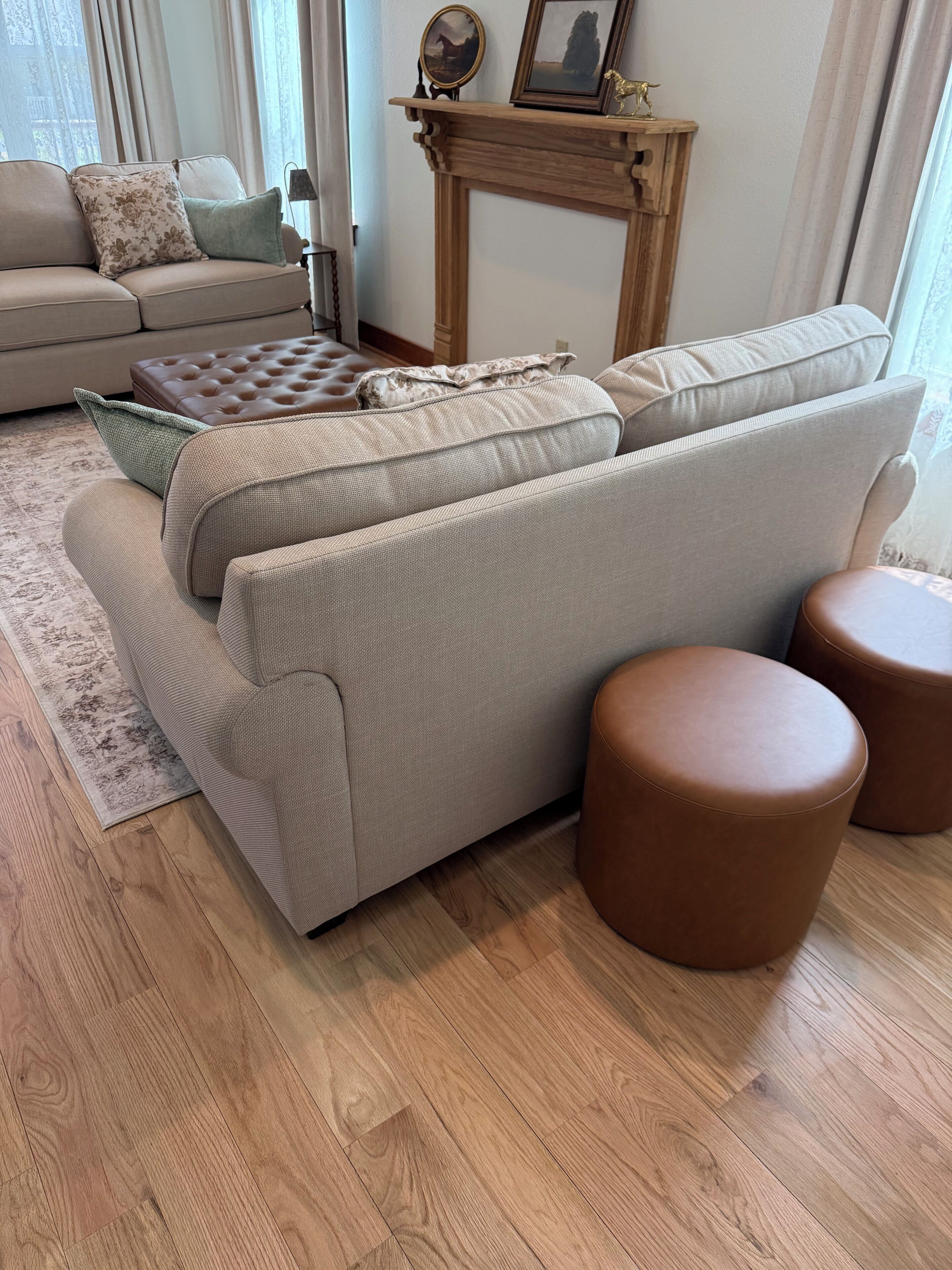 A living room with a sectional sofa, a small table, and two ottomans.