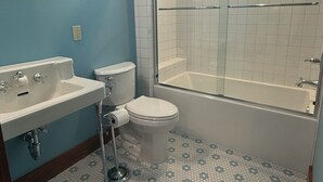 A bathroom with a toilet, sink, and bathtub. - The Mint Julep - Charming Cottage in Historic Fayetteville - near Round Top (Fayetteville)