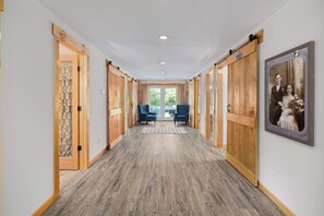 A hallway with wooden flooring, a patterned door, and a framed photograph on the wall. - Perfect location for family vacation or family gathering (Hyde Park)