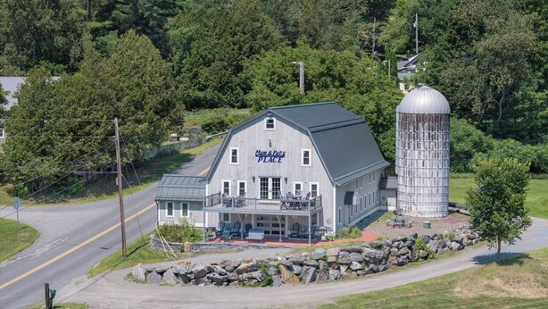 A two-story building with a sign 'Mum & Pup's PLACE' on the front, a covered outdoor seating area, and a silo structure to the right. - Perfect location for family vacation or family gathering (Hyde Park)