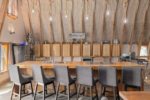 A modern kitchen with a central island, wooden cabinets, and a sign that reads 'Kitchen Open'.