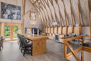 Ein großzügiges Loft mit hohen Decken, einer Küchenzeile und einem Essbereich mit Barhocker.