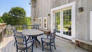 A deck with a round table and chairs, a large window, and a water tank. - Perfect location for family vacation or family gathering (Hyde Park)