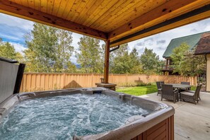 A hot tub under a wooden pergola with a view of a backyard and a house. - Walk to Downtown! Hot Tub! Garage Parking! (Steamboat Springs)