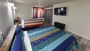 Une chambre moderne avec deux lits, une télévision et une fenêtre agrémentée de rideaux colorés.