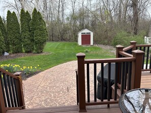 Enjoy a serene outdoor space with a paved deck, lawn, and garden, perfect for relaxation or outdoor activities.