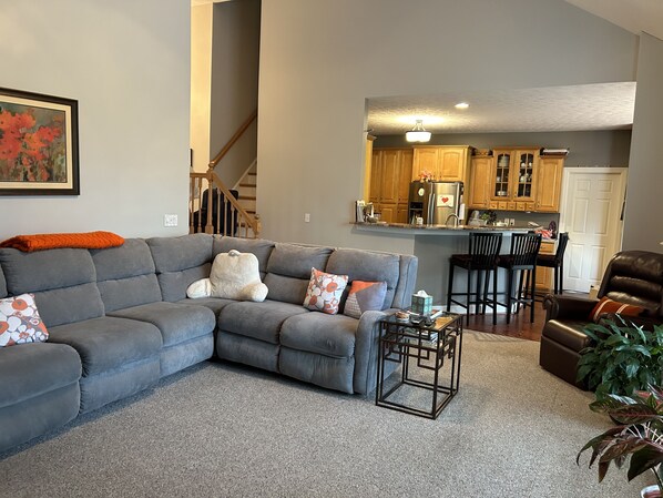 Relax in this stylish living room with a comfortable sofa, coffee table, and staircase leading to an upper level.