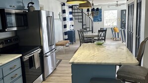Cozinha moderna com eletrodomésticos de aço inoxidável, bancada de mármore e uma ilha central.