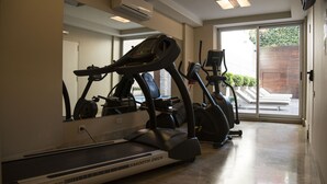 Een sportzaal thuis met een loopband, een elliptische trainer en een hometrainer.