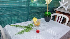 A table with a drink, a fern, and a red ornament.