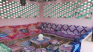 A room with a patterned wall, a sofa set, and a variety of colorful rugs. - Gohar Guest House (Giza)