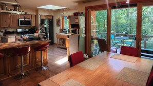 A spacious kitchen with a dining area, large windows, and a view of the outdoors. - Peaceful, Private Woodland Lot, 5 miles to UNC/Downtown CH. Stay 3 days-3 months (Chapel Hill)