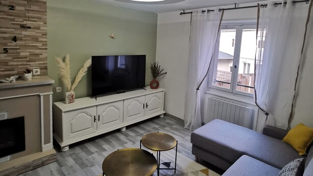 Olohuone, jossa on sohva, televisio ja takka.